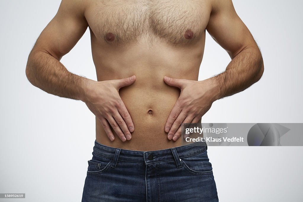 Close-up of man having stomach pain (front view)