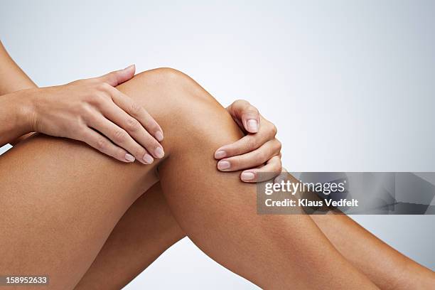 close up of woman having knee pain - womens legs stock-fotos und bilder