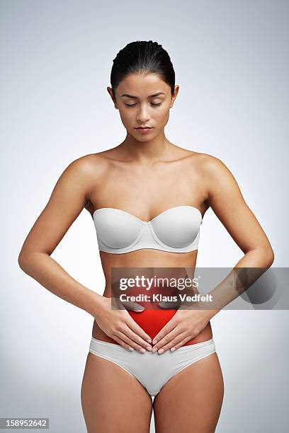 woman having stomach pain - bras photo studio stock-fotos und bilder