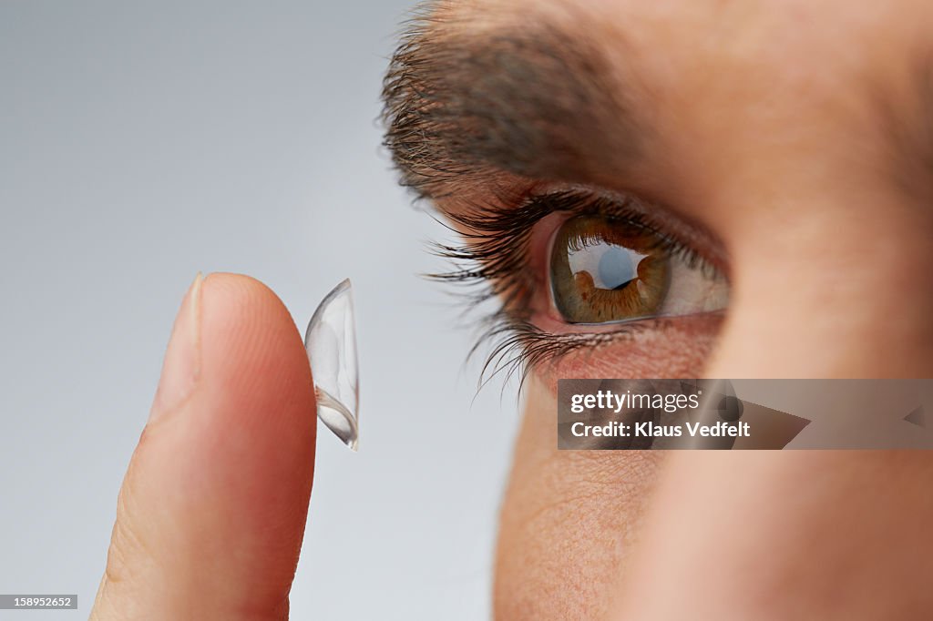 Close up of man putting in contact lens