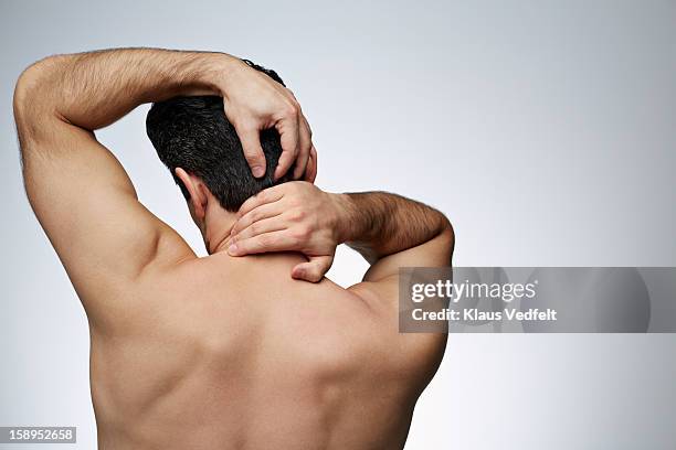 close-up of man having neck pain (rear view) - kopf in den händen stock-fotos und bilder