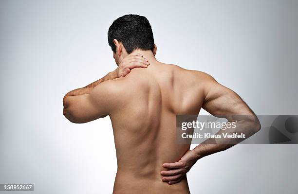 man having neck pain & back pain (rear view) - back pain man stock pictures, royalty-free photos & images