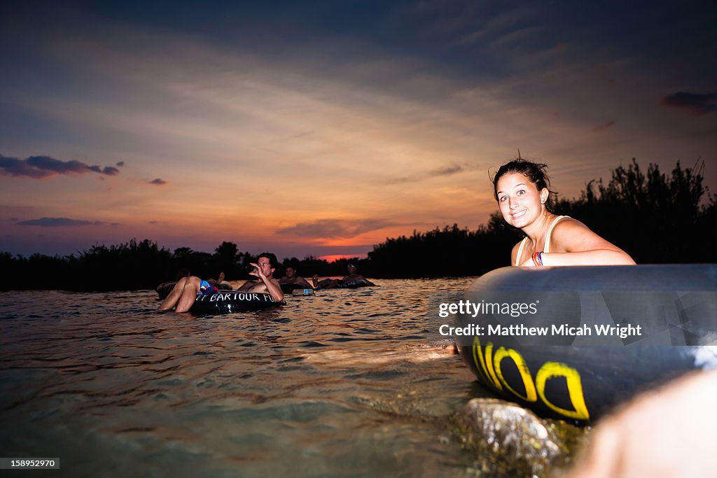 Travelers relax in tubes and take in the sunset