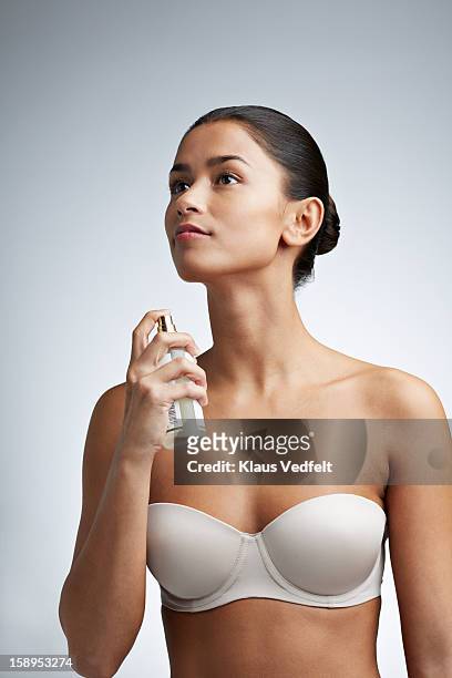 woman spraying perfume on her neck - perfume sprayer stock pictures, royalty-free photos & images