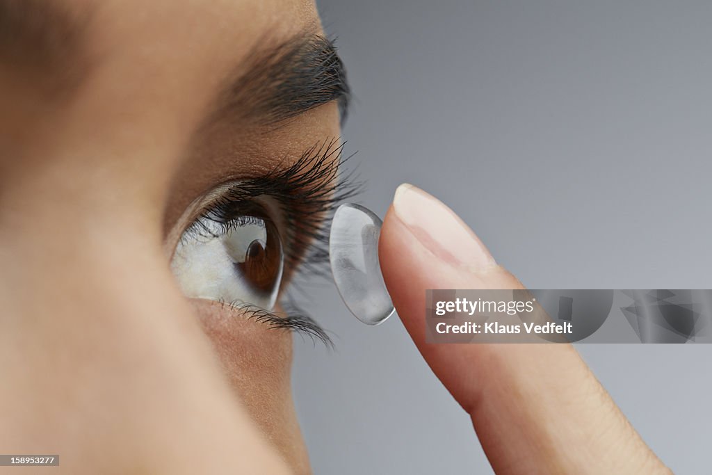 Close-up of woman putting in contact lens