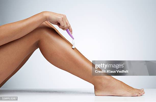 close-up of woman shaving her leg - barbear imagens e fotografias de stock