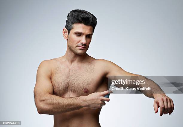 man spraying perfume in armpit - spraying deodorant stock pictures, royalty-free photos & images