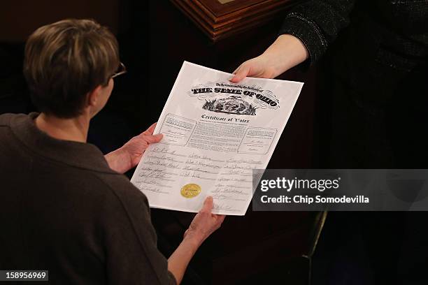 Congressional clerks pass the Electoral College certificate from the state of Ohio while unsealing and organizing all the votes from the 50 states in...