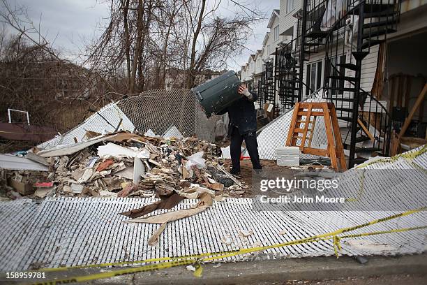 Laborer empties debris from a home damaged by Superstorm Sandy on January 4, 2013 in the Midland Beach area of the Staten Island borough of New York...