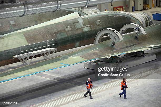 Workers prepare rotor blades for wind turbines at the Enercon wind turbine factory on January 4, 2013 in Aurich, Germany. Germany is invetsing...