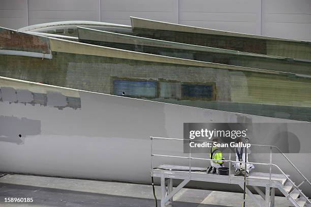 Workers prepare rotor blades for wind turbines at the Enercon wind turbine factory on January 4, 2013 in Aurich, Germany. Germany is invetsing...