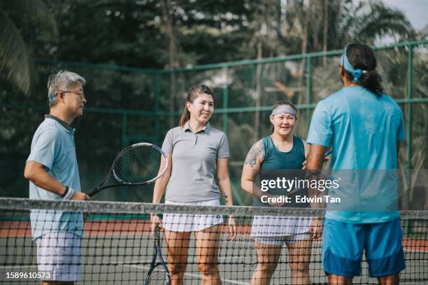asian tennis instructor showing adult students holding racket in tennis court - mission court grip stock pictures, royalty-free photos & images