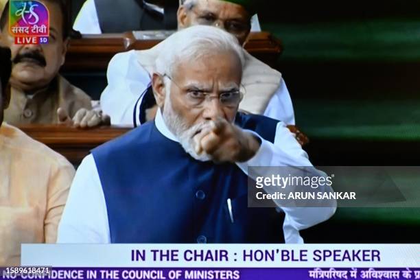 In this screen grab India's Prime Minister Narendra Modi is seen on a television screen as he addresses the lower house Lok Sabha in New Delhi on...