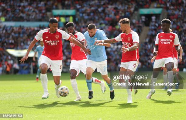 Manchester City's Mateo Kovacic gets in between Arsenal's William Saliba, Ben White and Thomas Partey during The FA Community Shield match between...