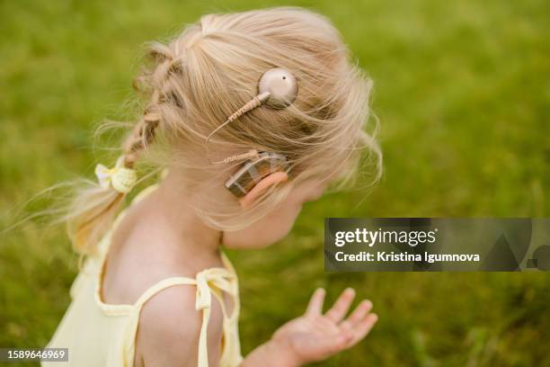 child girl with cochlear implant playing outdoors. copy space and empty place for text - cochlea implant stock pictures, royalty-free photos & images