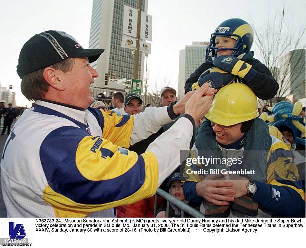 Missouri Senator John Ashcroft greets five-year-old Danny Hughey and his dad Mike during the Super Bowl victory celebration and parade in St.Louis,...