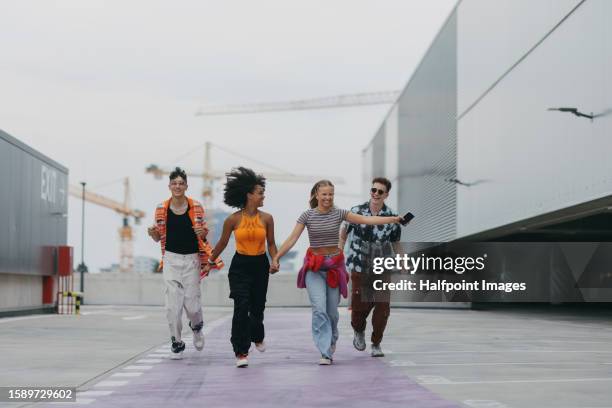 diverse group of generation z friends hanging out together outdoors in the city. - z com stock pictures, royalty-free photos & images