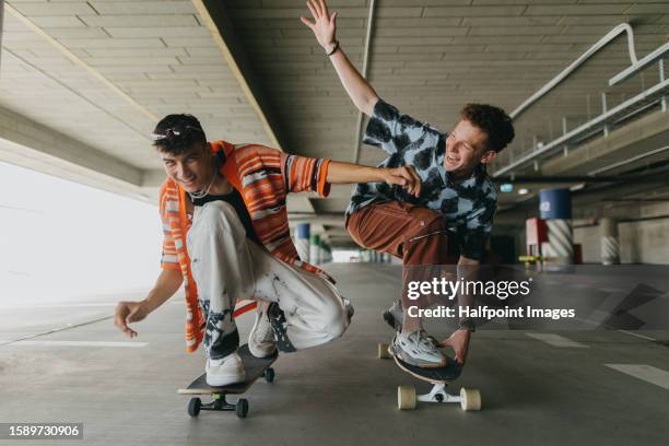 generation z friends riding skateboards in parking garage. - modern boy hipster stock-fotos und bilder