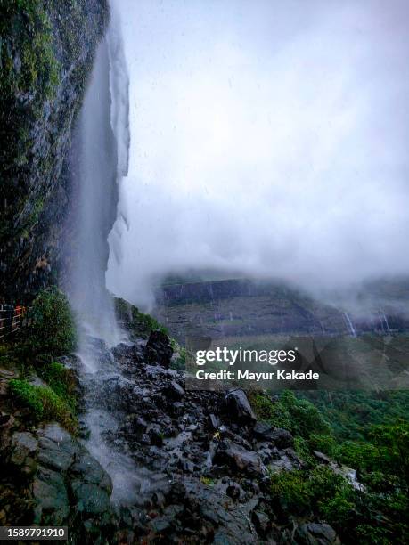 scenic waterfall against cloudy sky - waterfall stock pictures, royalty-free photos & images