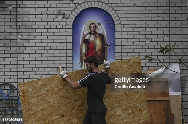 Man carries wooden panel at a damaged church after an attack launched by Russian forces as debris removal efforts continue in Zaporizhzhia, Ukraine...