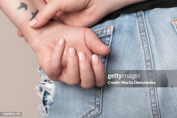 hands with beautiful manicure - pink gel nails - vaqueros color carne fotografías e imágenes de stock