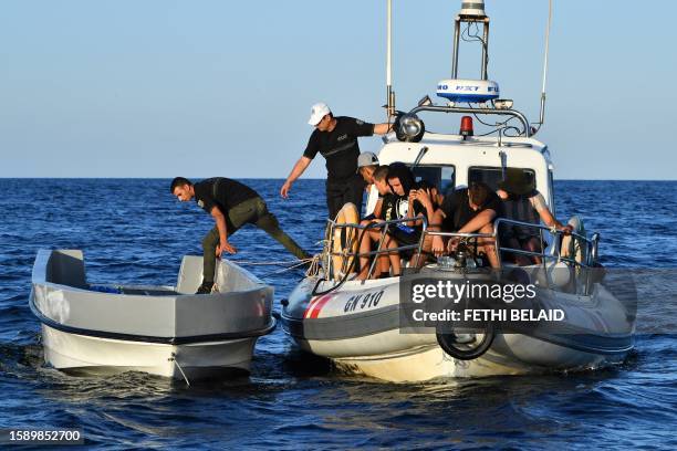 Tunisians trying to flee to Europe gather aboard a ship owned by the Tunisian coast guards, after being intercepted by them at sea on August 10,...