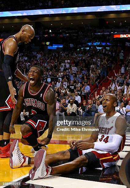 Nate Robinson of the Chicago Bulls and Ray Allen of the Miami Heat react to a play during a game at AmericanAirlines Arena on January 4, 2013 in...