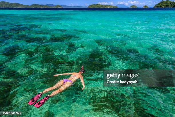 young female tourist snorkeling on east china sea, philippines - el nido stockfoto's en -beelden