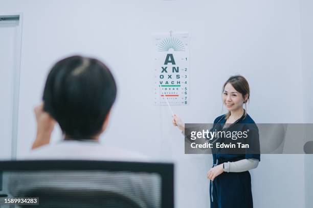 asian chinese female doctor performing eye test with senior patient on optical vision test vector chart - text vector stock pictures, royalty-free photos & images