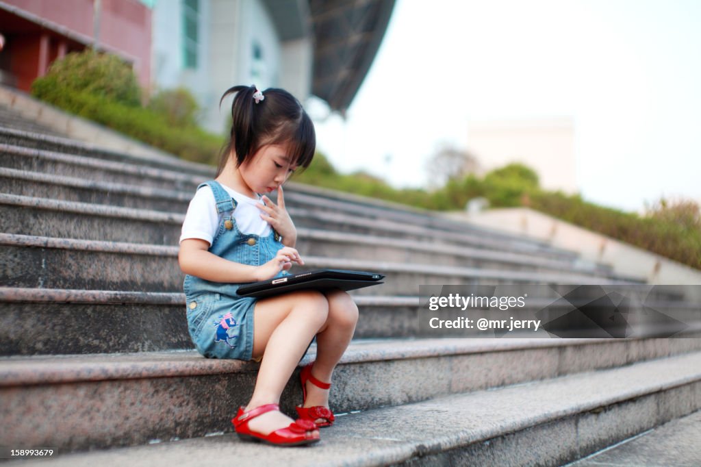 Cute girl playing with a tablet computer