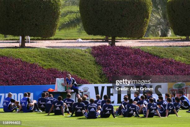 Head coach Jens Keller talks to the players during a Schalke 04 training session at the ASPIRE Academy for Sports Excellence on January 5, 2013 in...