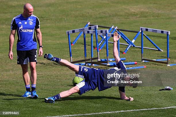 Christian Fuchs exercises with athletics coach Ruwen Faller during a Schalke 04 training session at the ASPIRE Academy for Sports Excellence on...