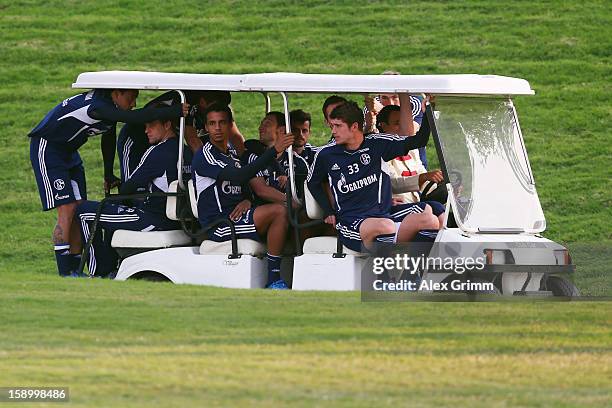Players arrive in a golf cart for a Schalke 04 training session at the ASPIRE Academy for Sports Excellence on January 5, 2013 in Doha, Qatar.