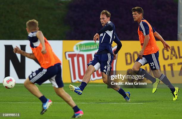 Benedikt Hoewedes is challenged by Klaas-Jan Huntelaar and Lewis Holtby during a Schalke 04 training session at the ASPIRE Academy for Sports...