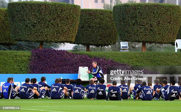 Head coach Jens Keller talks to the players during a Schalke 04 training session at the ASPIRE Academy for Sports Excellence on January 5, 2013 in...