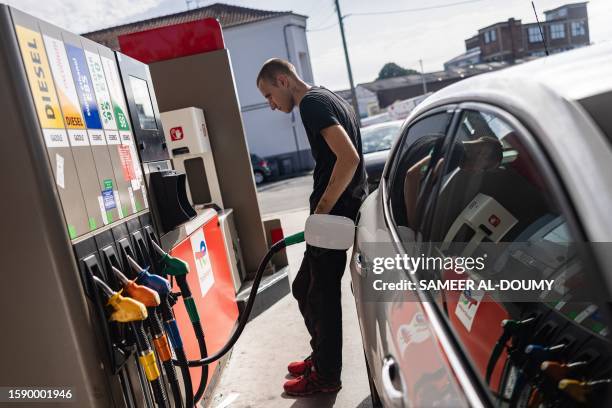 Motorist fills his car at a Total Energies petrol station in Faches-Thumesnil near Lille, northern France on August 10, 2023.