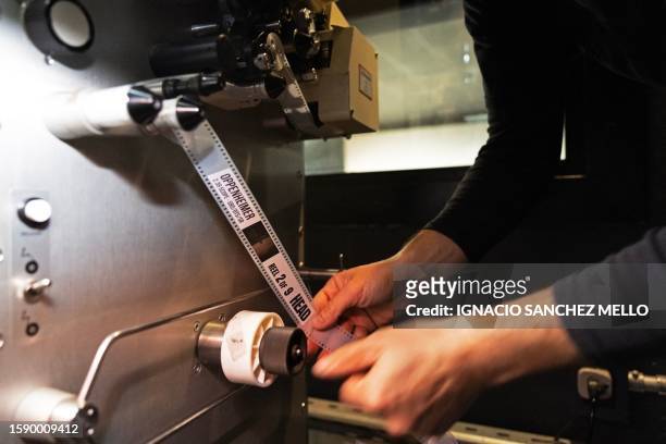 Projectionist Martin Ramirez loads a film reel of Christopher Nolan's "Oppenheimer" into a projector before its screening at the Cinemateca Uruguaya...