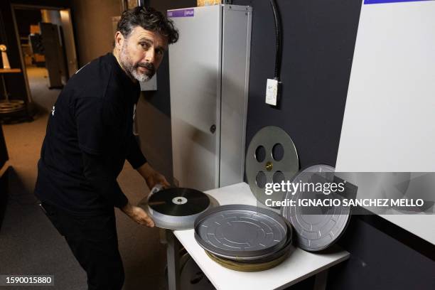 Projectionist Martin Ramirez prepares a film reel of Christopher Nolan's "Oppenheimer" before its screening at the Cinemateca Uruguaya cinematheque...