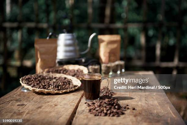 close-up of coffee beans on table - heri mardinal stock pictures, royalty-free photos & images