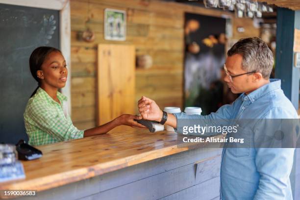 man paying for a coffee with his smart watch - cape town stock pictures, royalty-free photos & images
