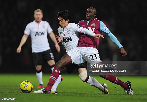 Shinji Kagawa of Manchester United and Alou Diarra of West Ham United tussle for the ball during the FA Cup with Budweiser Third Round match between...