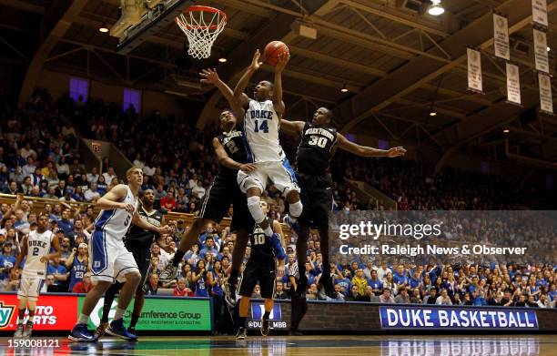 Duke guard Rasheed Sulaimon goes in against Wake Forest forward Devin Thomas and forward Travis McKie in the second half at Cameron Indoor Stadium in...