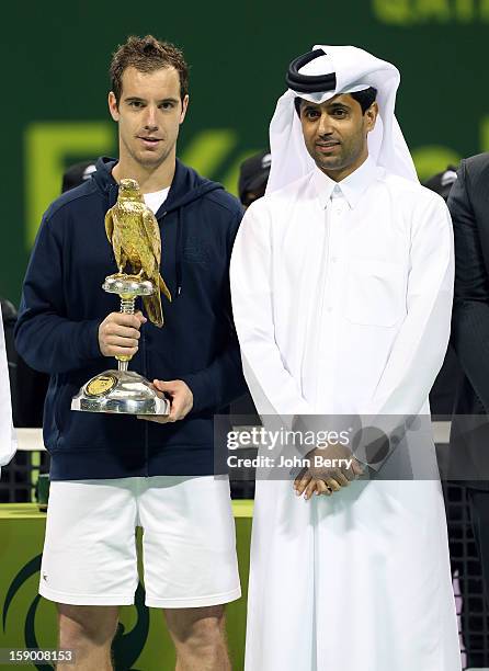 Richard Gasquet of France lifts the trophy and poses with Nasser Al-Khelaifi, President of the Qatar Tennis Federation and President of Paris...