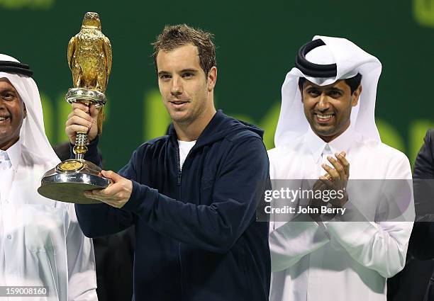 Richard Gasquet of France lifts the trophy and poses with Nasser Al-Khelaifi, President of the Qatar Tennis Federation and President of Paris...