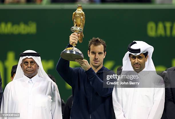 Richard Gasquet of France lifts the trophy and poses with Nasser Al-Khelaifi, President of the Qatar Tennis Federation and President of Paris...