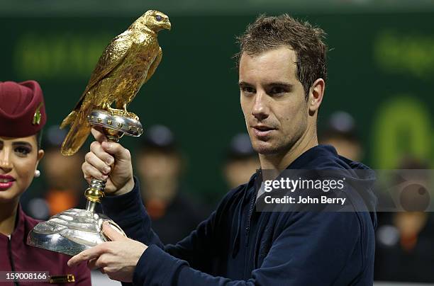 Richard Gasquet of France lifts the trophy after defeating in final Nikolay Davydenko of Russia in day six of the Qatar Open 2013 at the Khalifa...