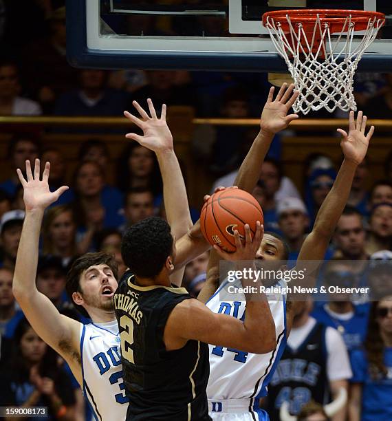 Duke forward Ryan Kelly and guard Rasheed Sulaimon defend as Wake Forest forward Devin Thomas attempts a first-half shot at Cameron Indoor Stadium in...