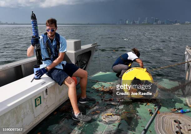 Bradley Schonhoff and Nick Evans conduct routine maintenance on a research buoy in Biscayne Bay on August 03, 2023 in Miami, Florida. Evans is...