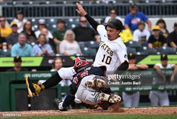 Bryan Reynolds of the Pittsburgh Pirates slides in safely to score a run past a tag attempt by Travis d'Arnaud of the Atlanta Braves in the third...