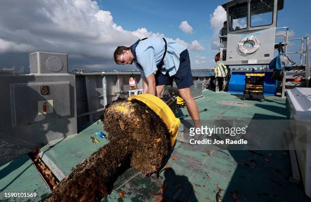 Bradley Schonhoff conducts routine maintenance on a research buoy in Biscayne Bay on August 03, 2023 in Miami, Florida. Schonhoff is the Program...